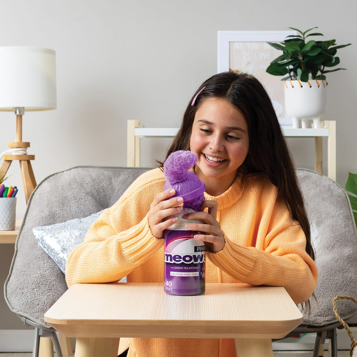 Girl opening the top of a purple Misfittens package